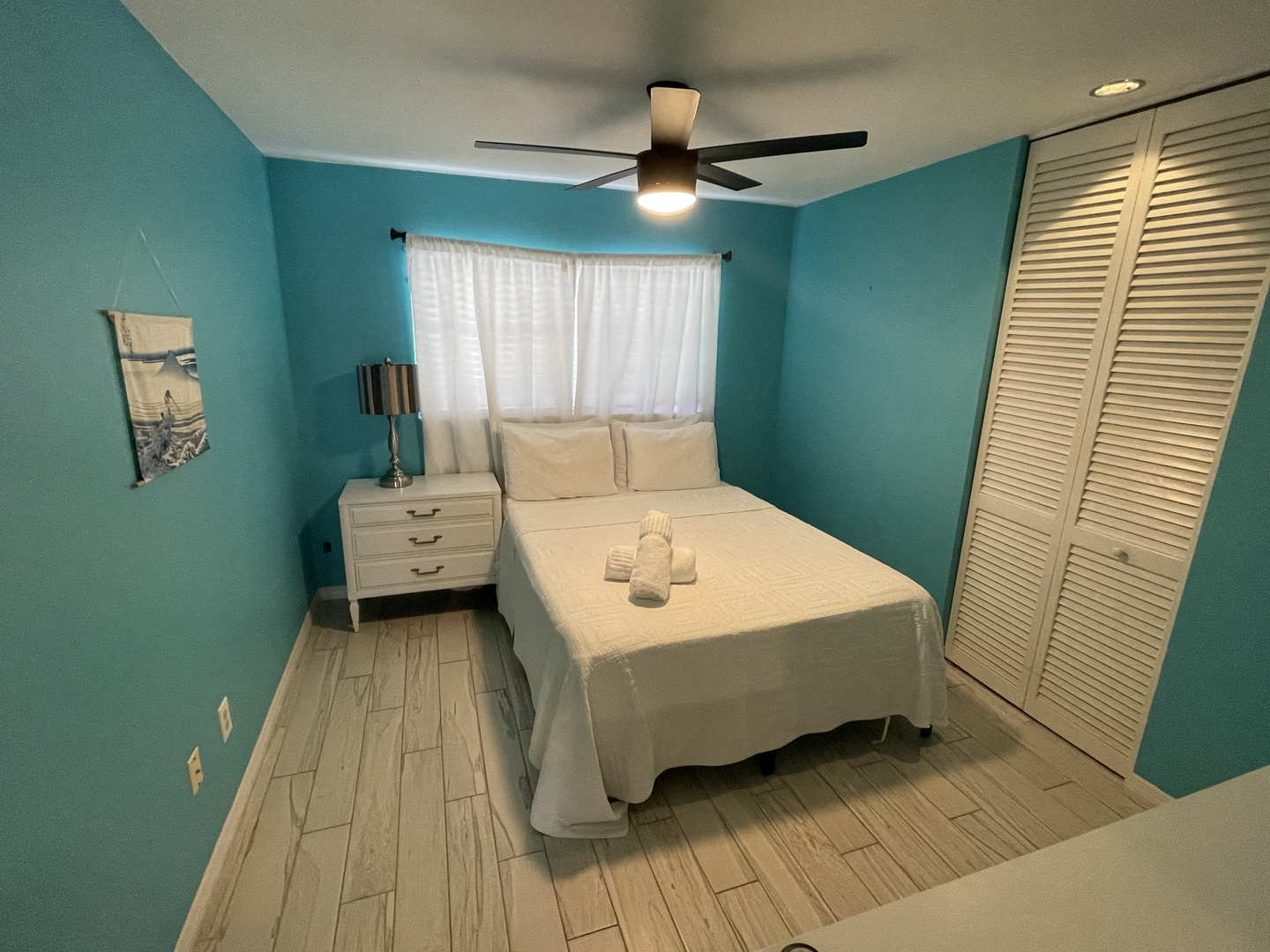 The final bedroom offers a plush queen bed & ceiling fan