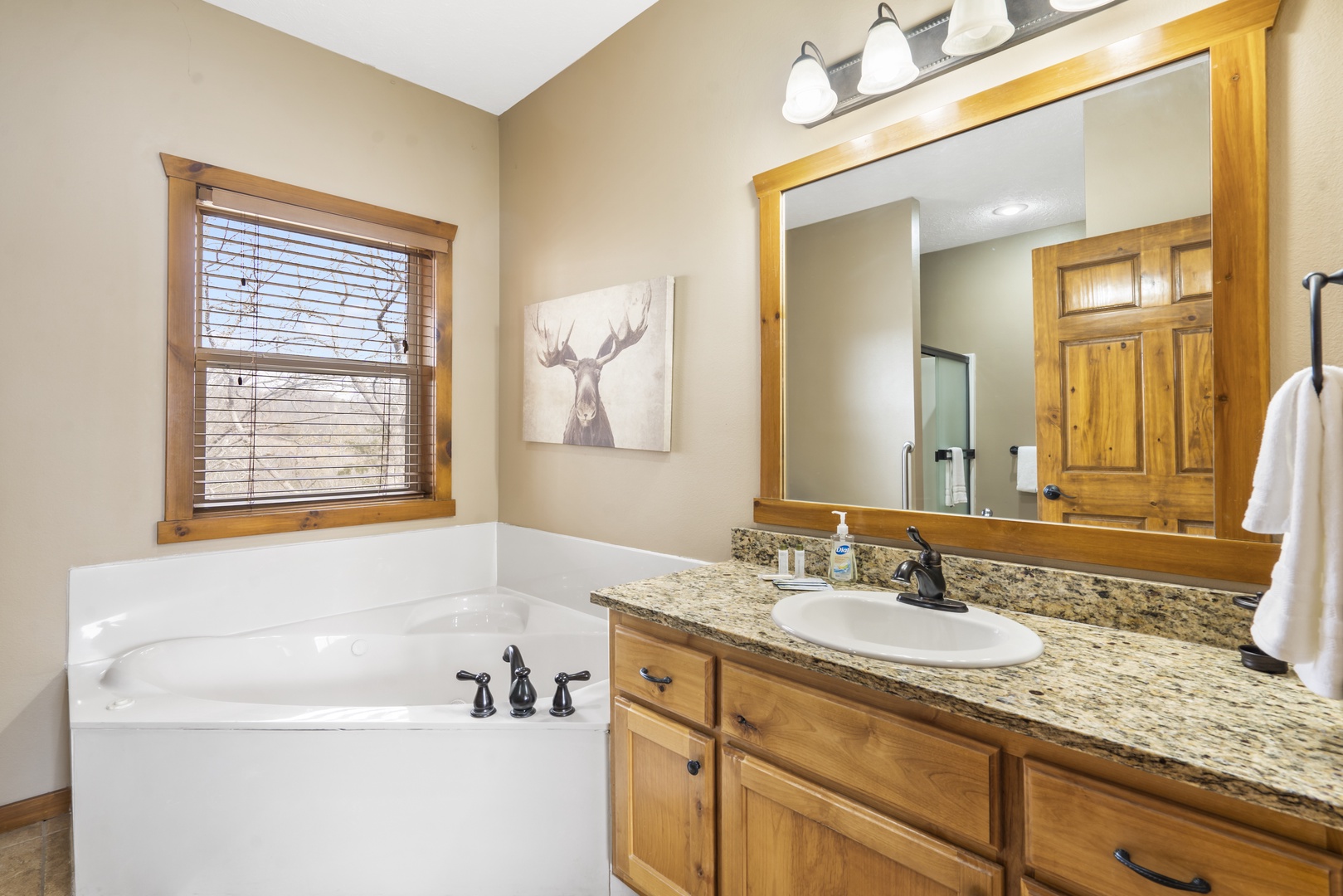 This ensuite bath offers a single vanity, shower, & Jacuzzi bathtub