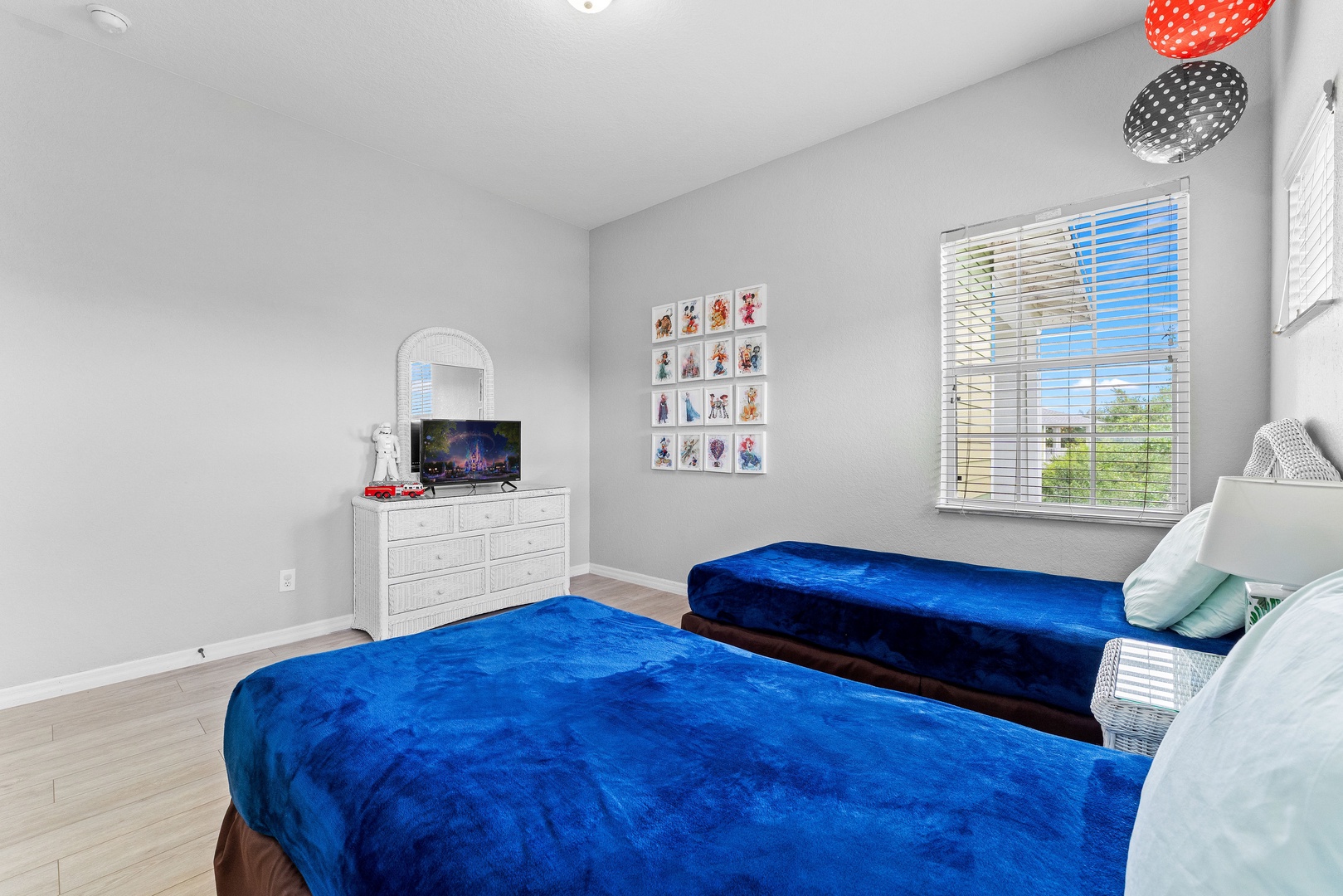 Room with 2 twin beds, decorated with fun Disney-themed decals and accents