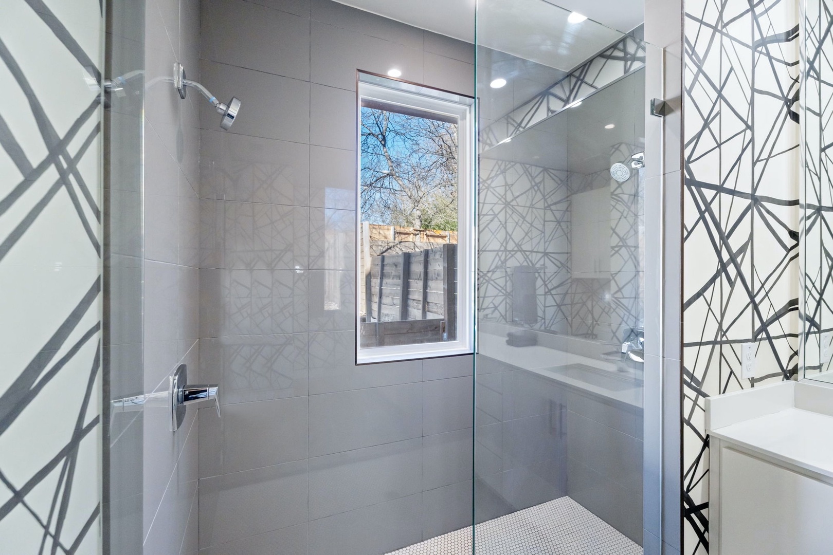 The primary ensuite on the main floor includes a dual vanity & glass shower
