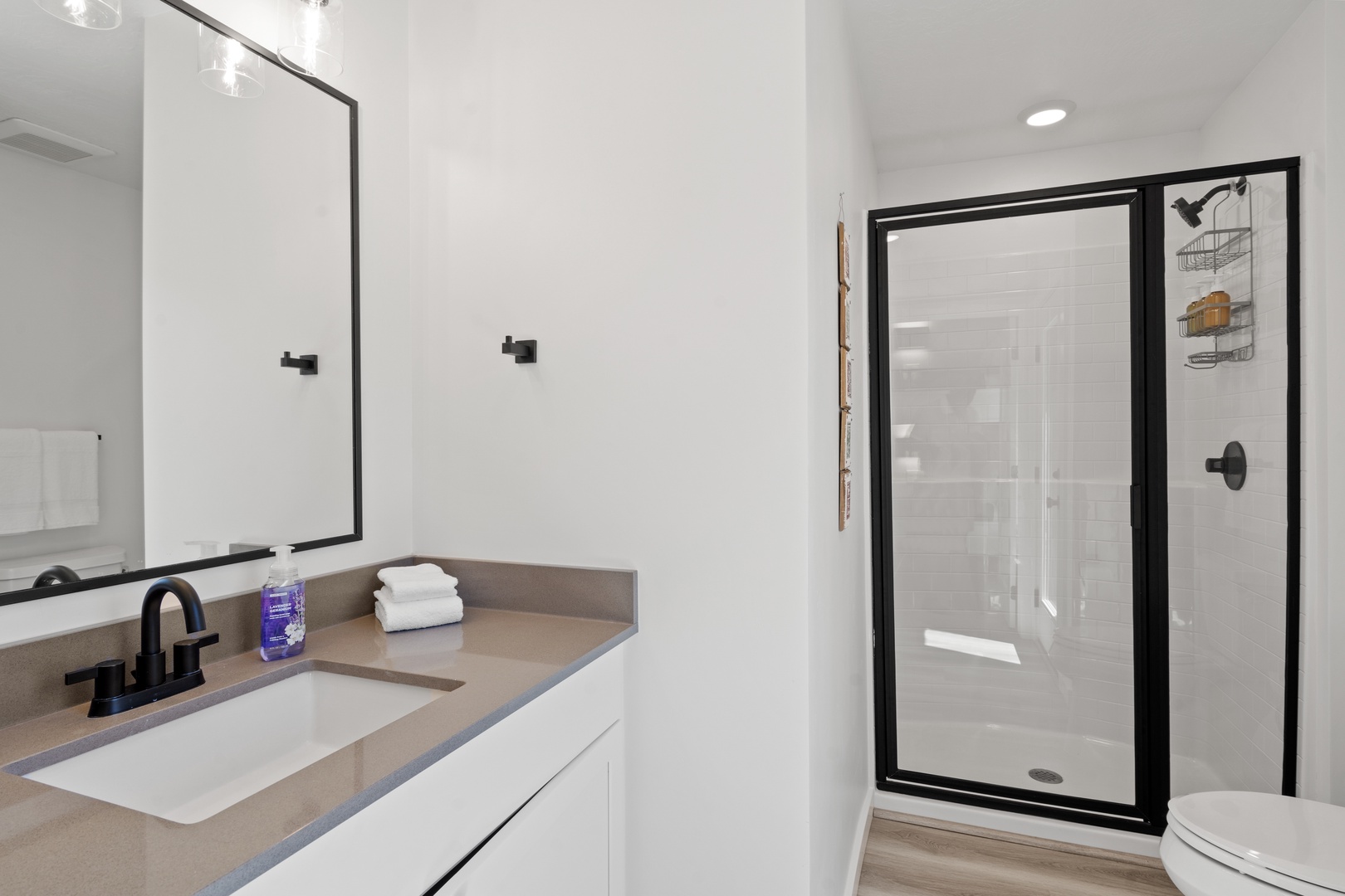 The final ensuite showcases a single vanity & sleek glass shower