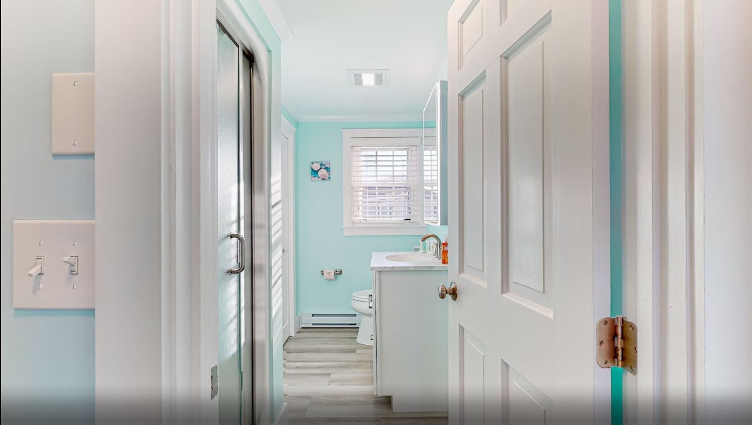 A single vanity & walk-in shower await in this beachy ensuite bath