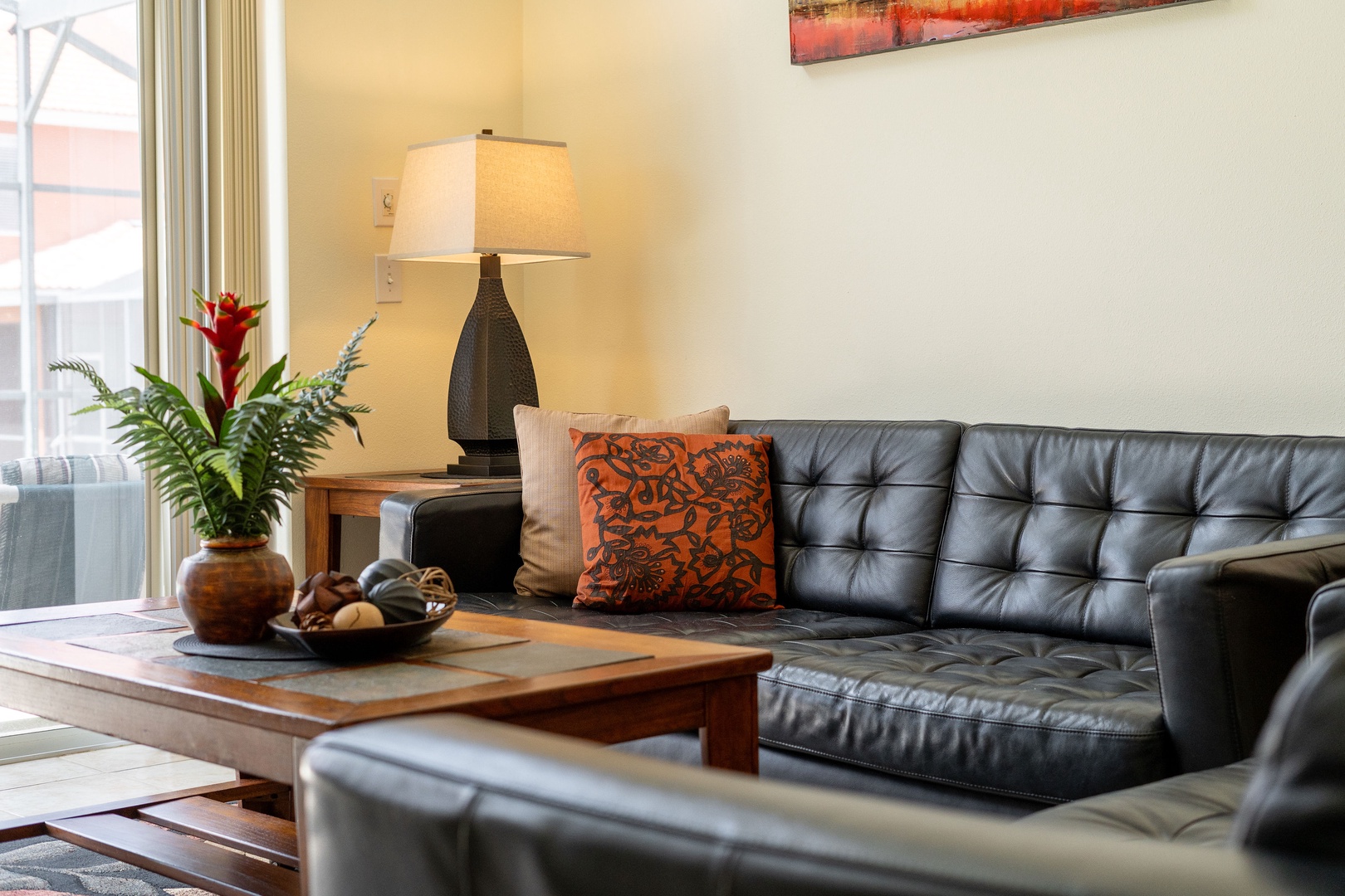 Rear living room with cozy seating and ceiling fan and access to lanai