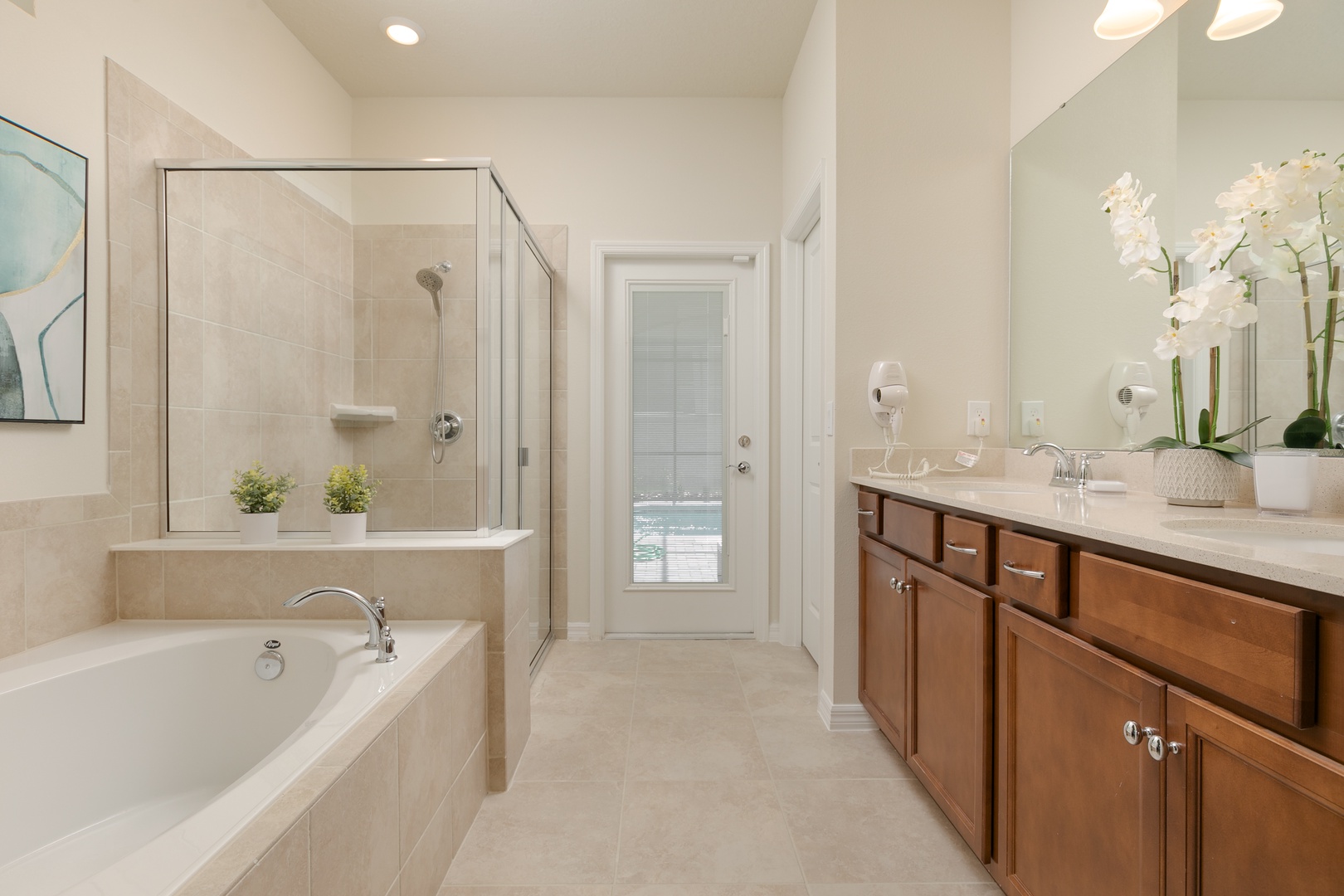The king en suite offers a dual vanity, glass shower, soaking tub, & patio access