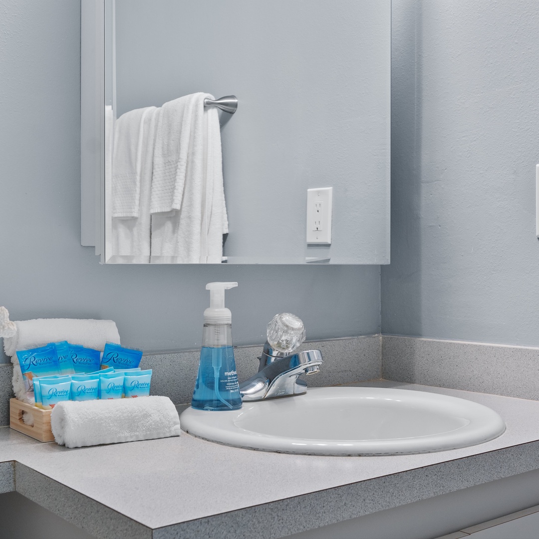 This shared full bath offers a single vanity & shower/tub combo