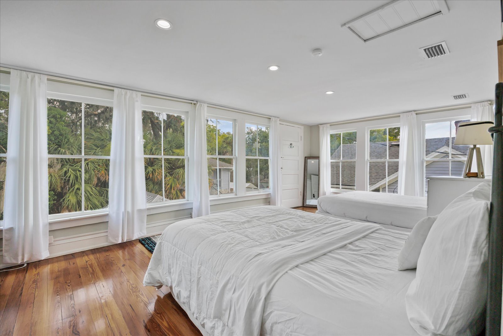 The larger bedroom includes two full-sized beds & serene sitting area