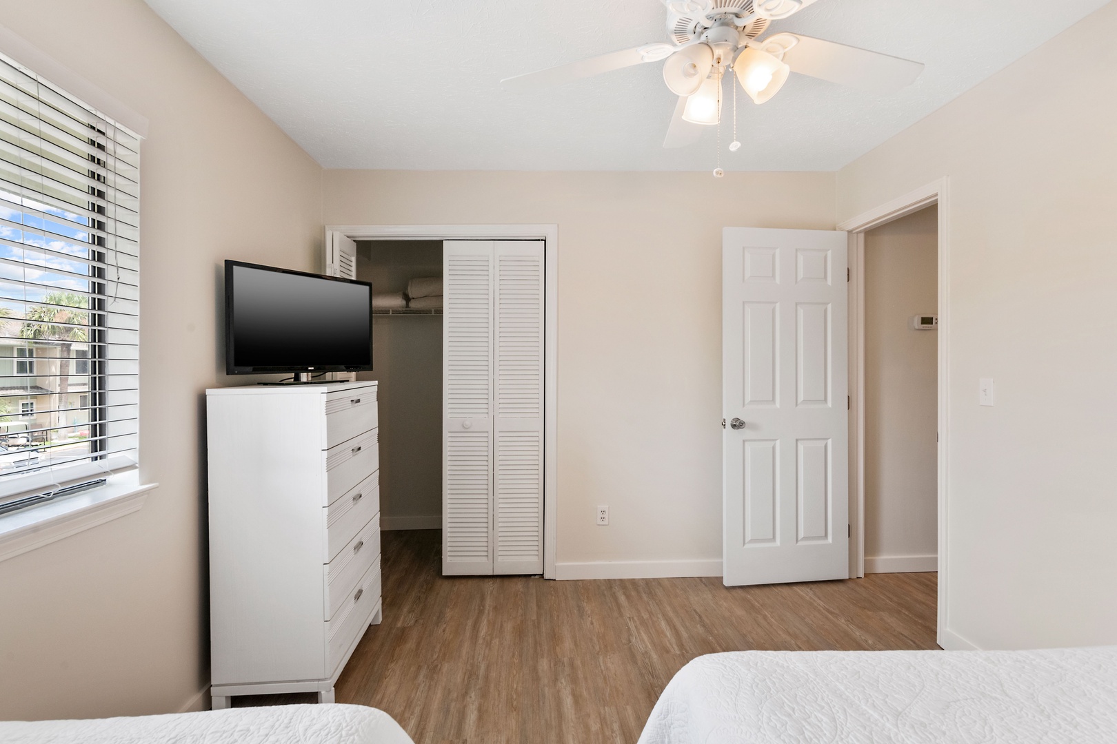 A queen bed, twin bed, & smart TV await in the second bedroom