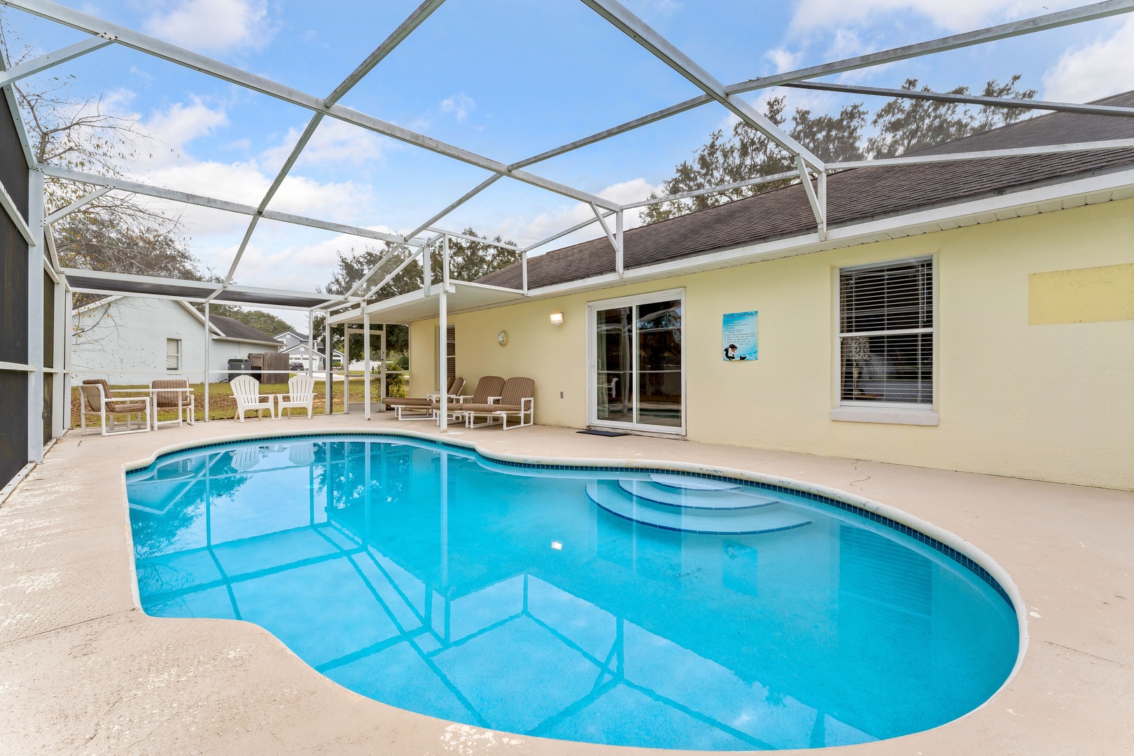 Enjoy the pool and lounge chairs under a serene lanai