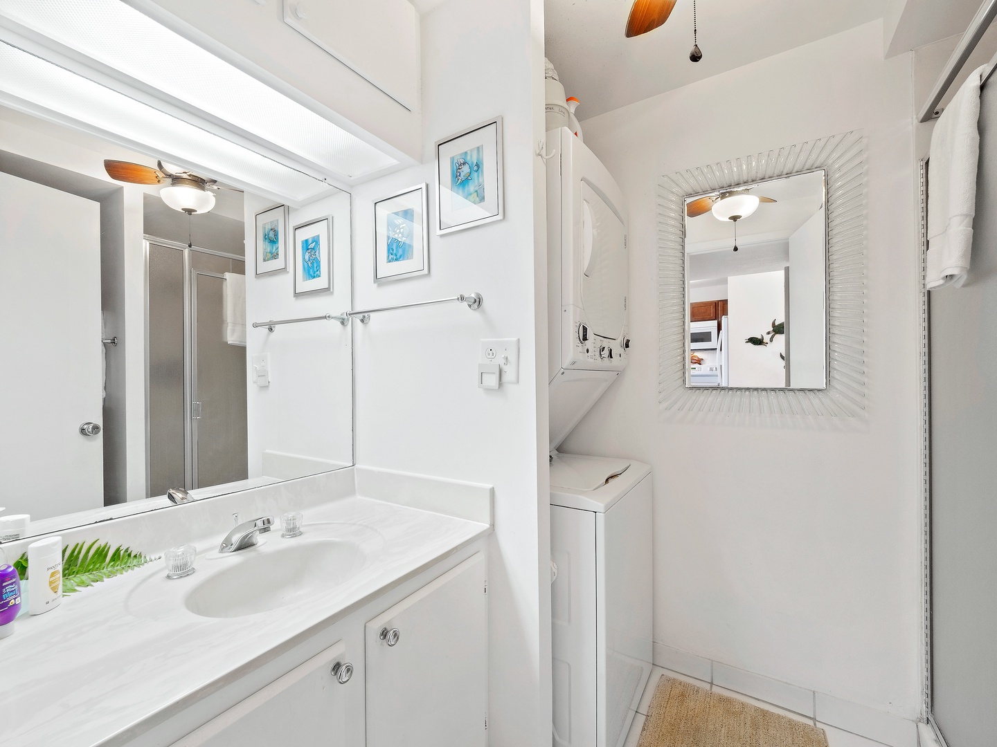Shared bathroom with stand up shower, and stacked washer and dryer