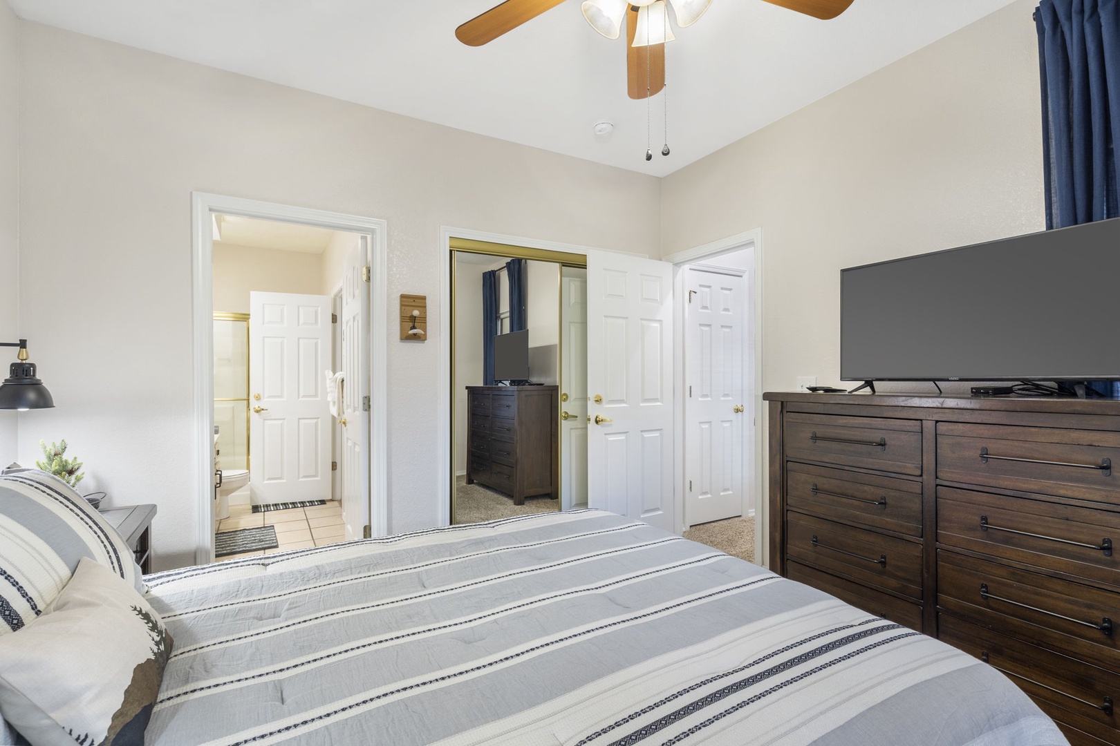 This cozy bedroom offers a queen bed, en suite bathroom, & Smart TV