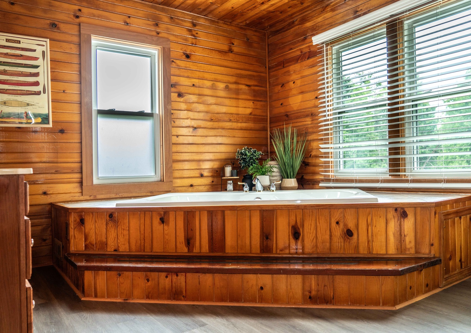 The full bath features a single vanity, glass shower, & luxe soaking tub