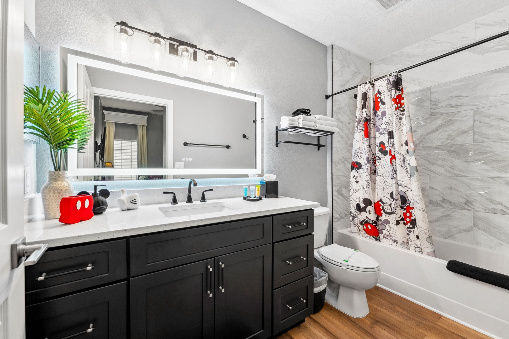 Wash up in this Mickey-themed ensuite, offering a shower/tub combo