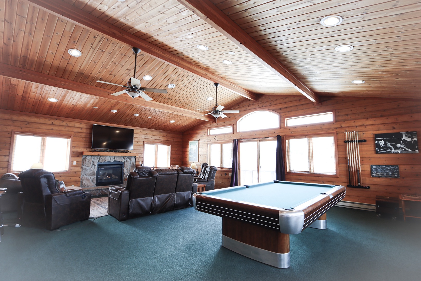 Living room 1 with reclining leather seating, fireplace, TV, and pool table