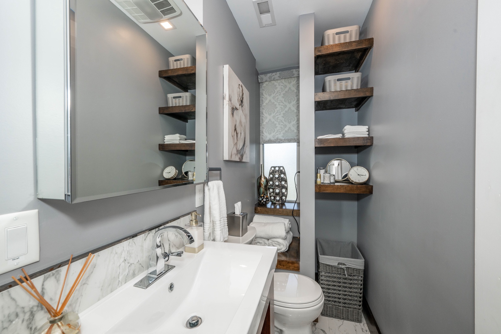 The chic full bath features a single vanity & glass shower