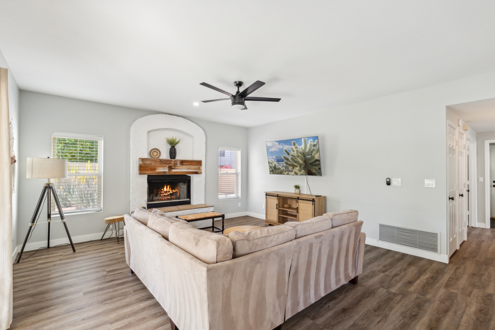 Living space off of the back yard with sectional sofa, fireplace, and Smart TV