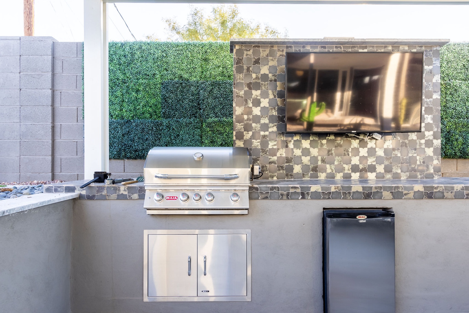 Gas BBQ grill and TV in the outdoor kitchen