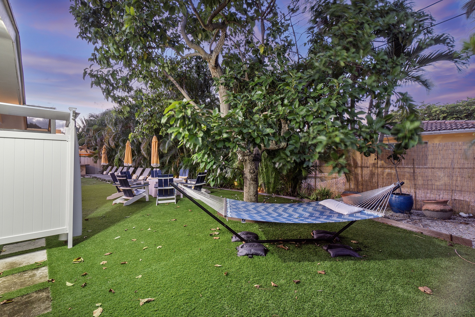 Back yard with covered pool, extensive seating, grill, hammock, and firepit