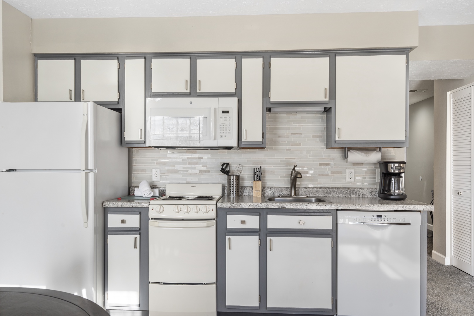 The airy kitchen area offers ample storage space & all the comforts of home