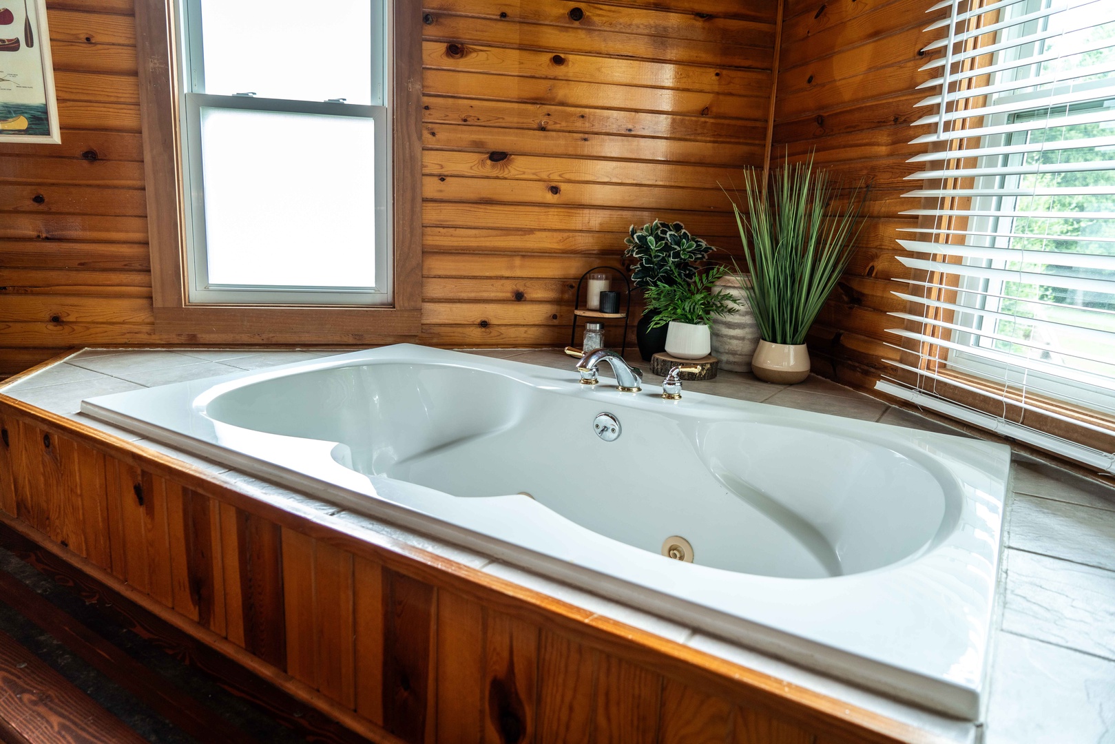 The full bath features a single vanity, glass shower, & luxe soaking tub