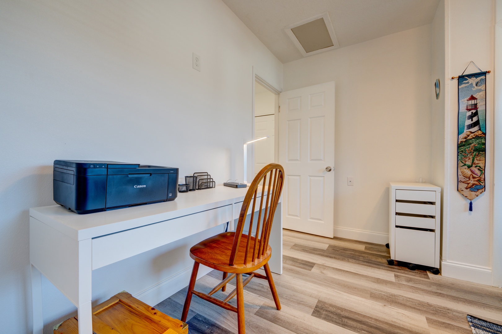 This bedroom features a cozy full-size futon & desk space & ceiling fan