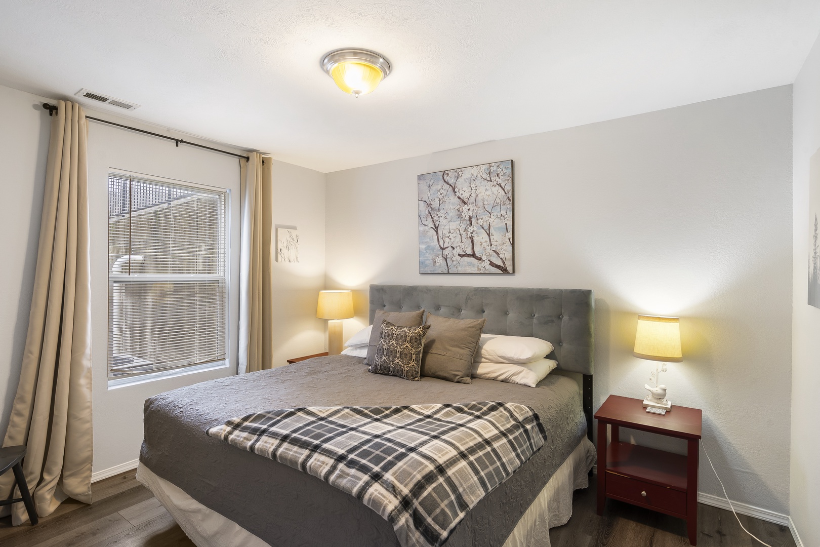 Cozy up in the first bedroom, featuring a queen bed & Smart TV