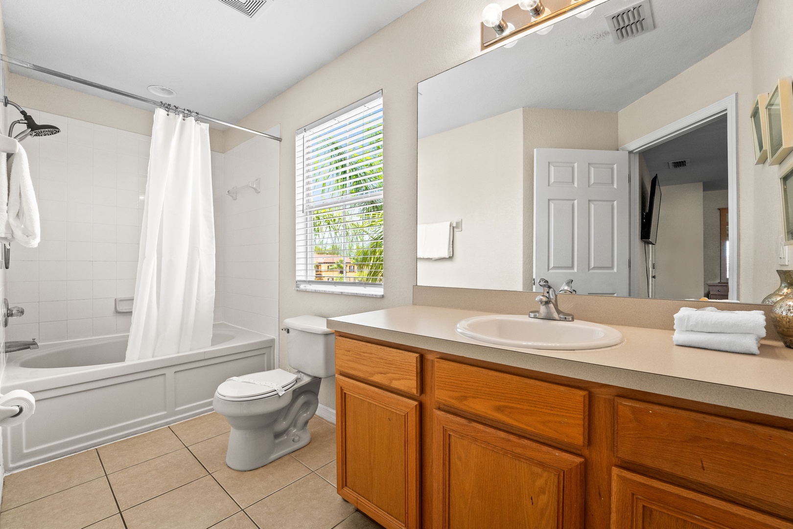 Private ensuite featuring an oversized tub, single vanity, and separate shower