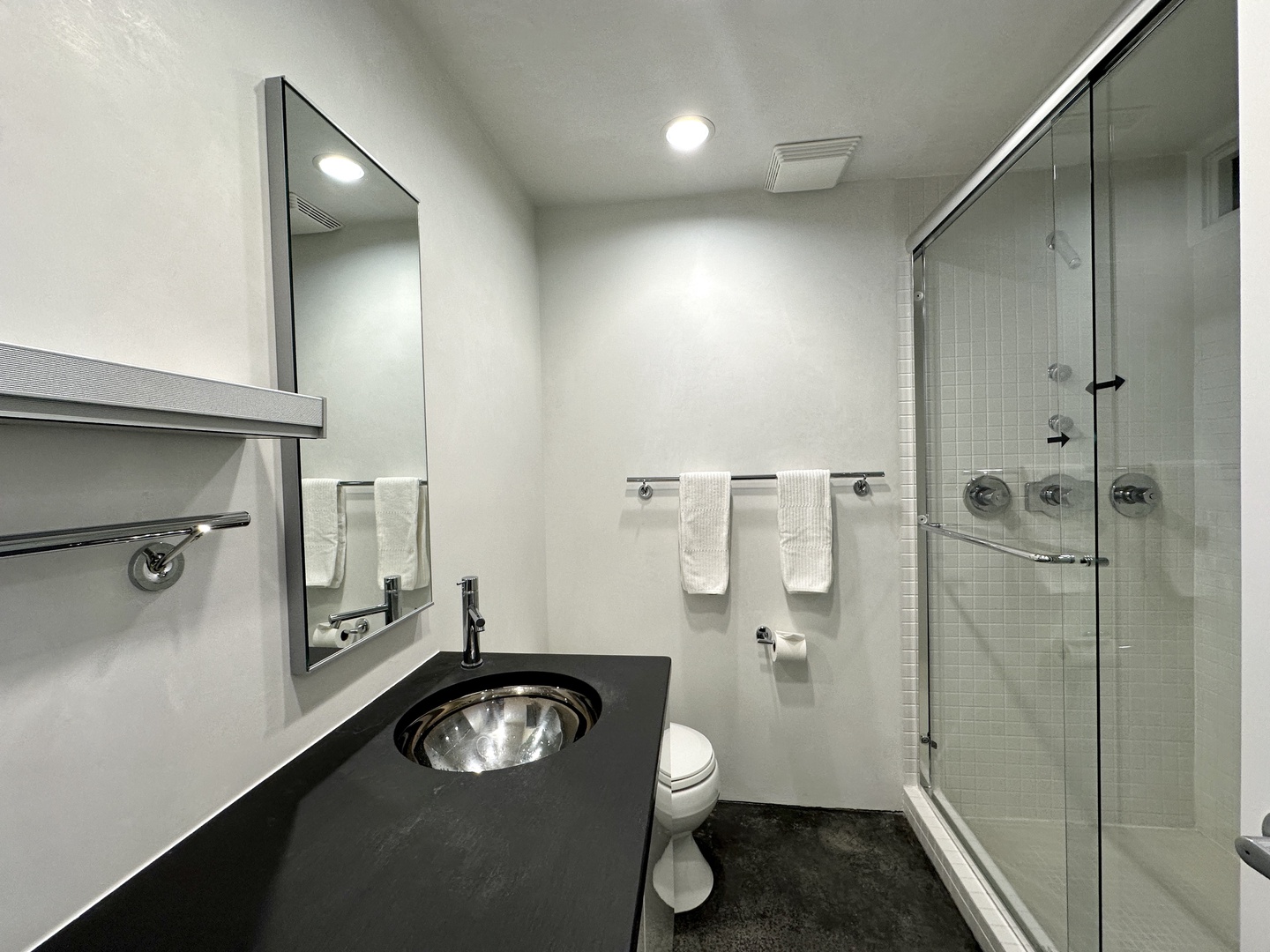 A second main-level ensuite offers a large vanity & glass shower