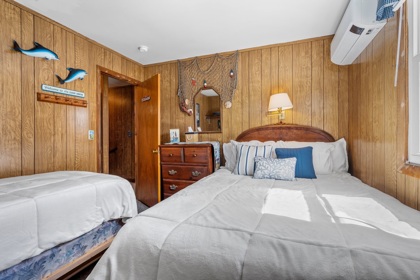 Bedroom 3 with queen bed, twin bed, and partial ocean view