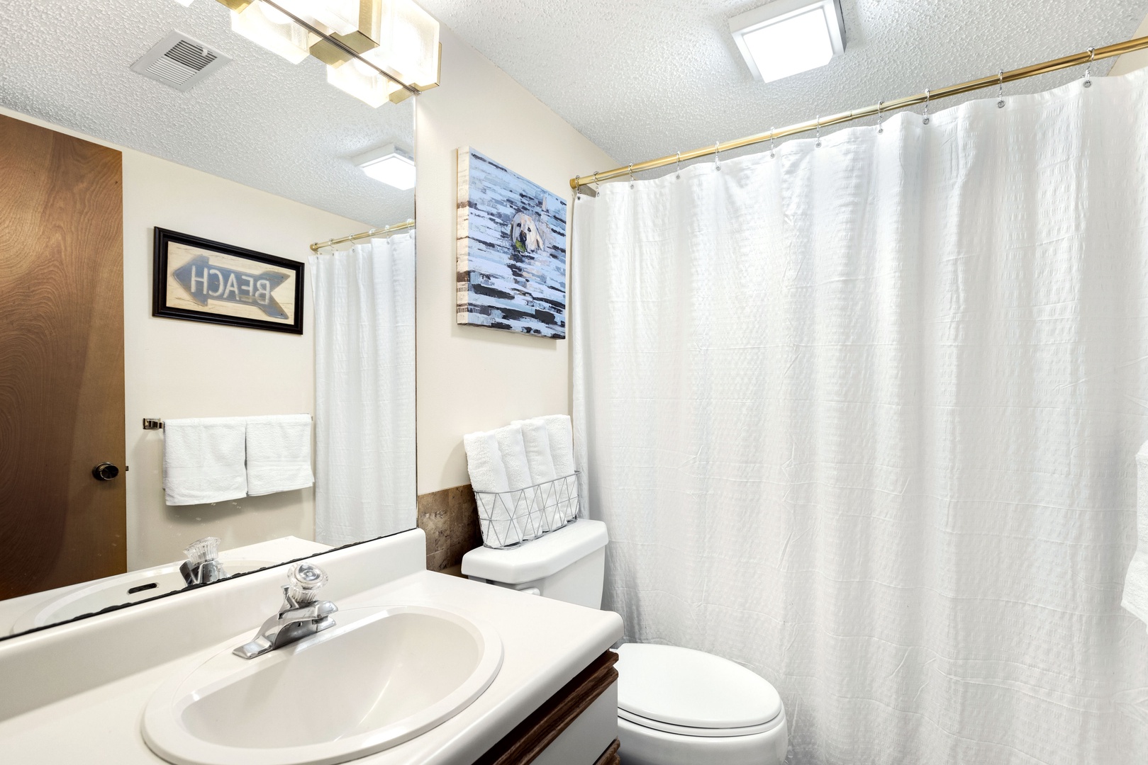 The shared full bathroom features a single vanity & shower-tub combination