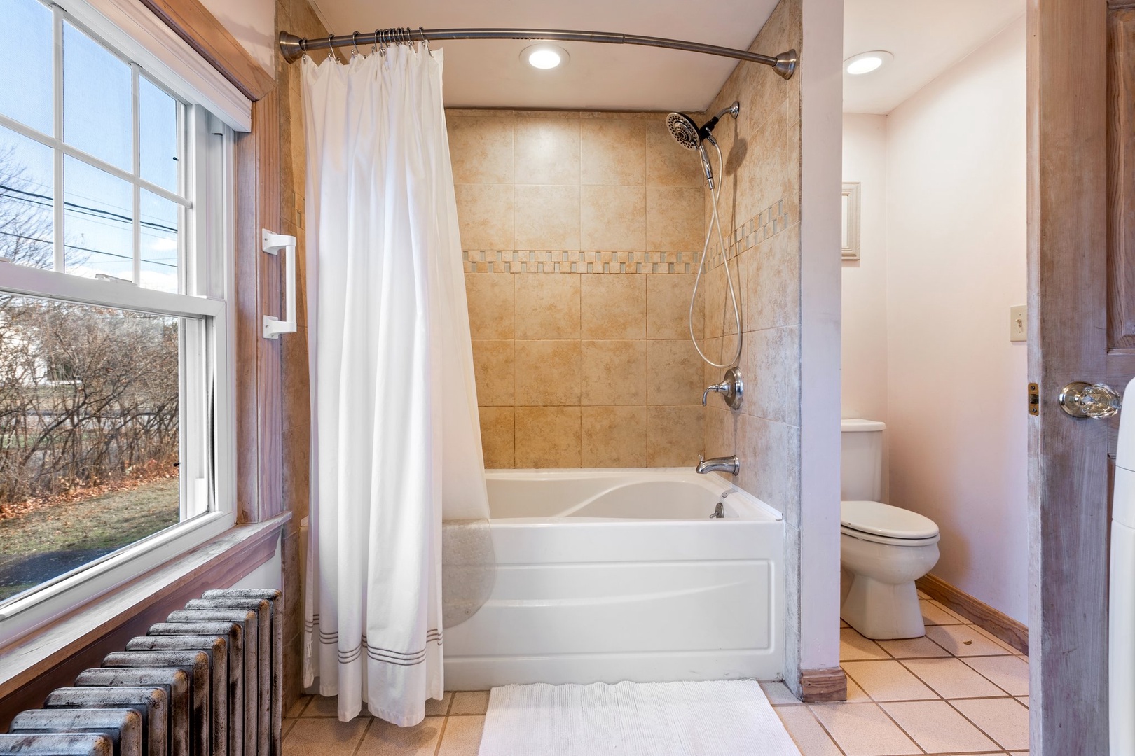 First floor shared bathroom with shower/tub combo & laundry room