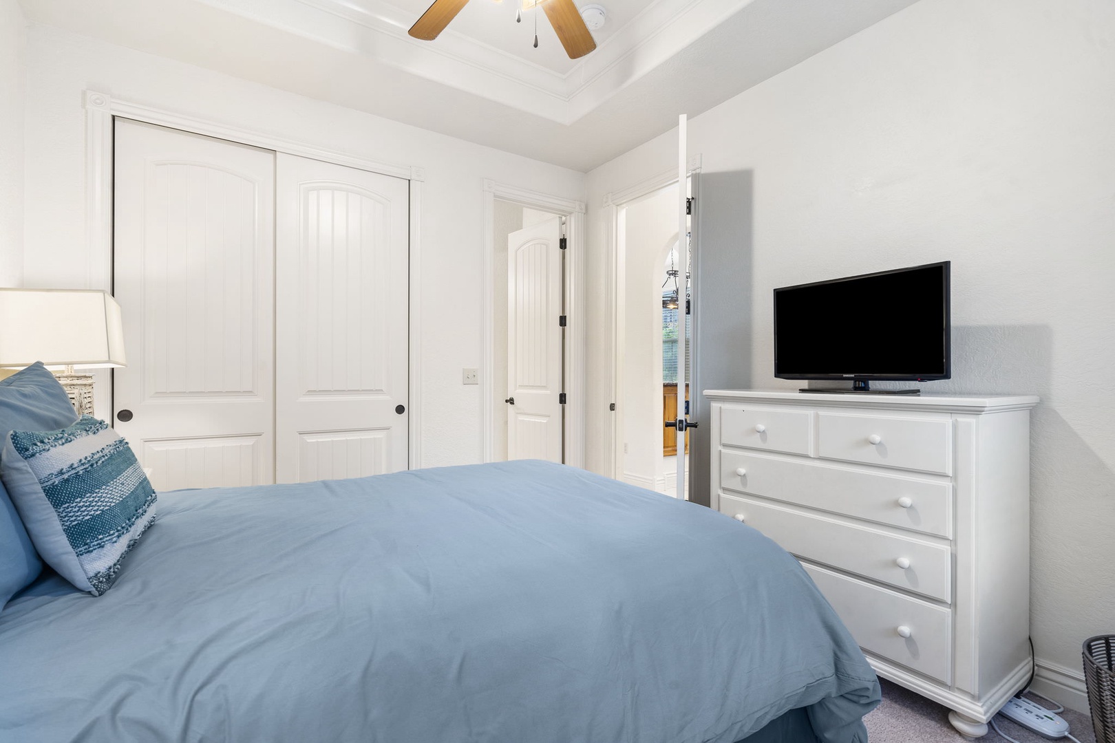 The queen suite offers a private en suite, ceiling fan, & Smart TV