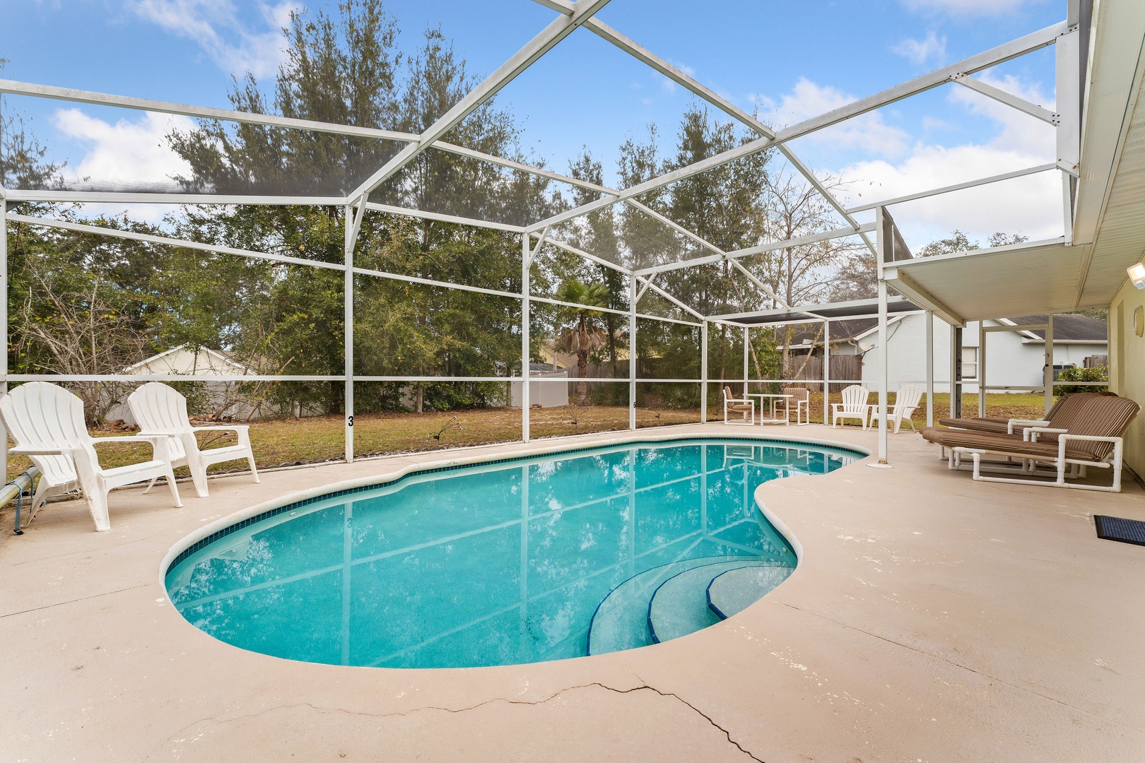 Enjoy the pool and lounge chairs under a serene lanai