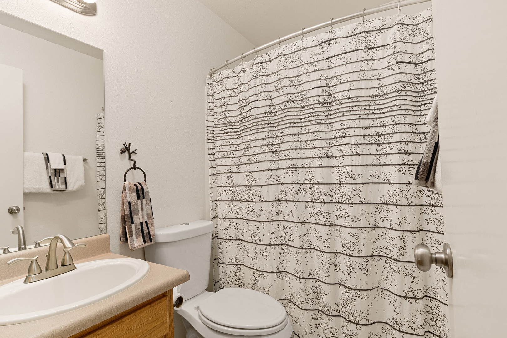 This ensuite bathroom features a shower/tub combo and a single vanity.