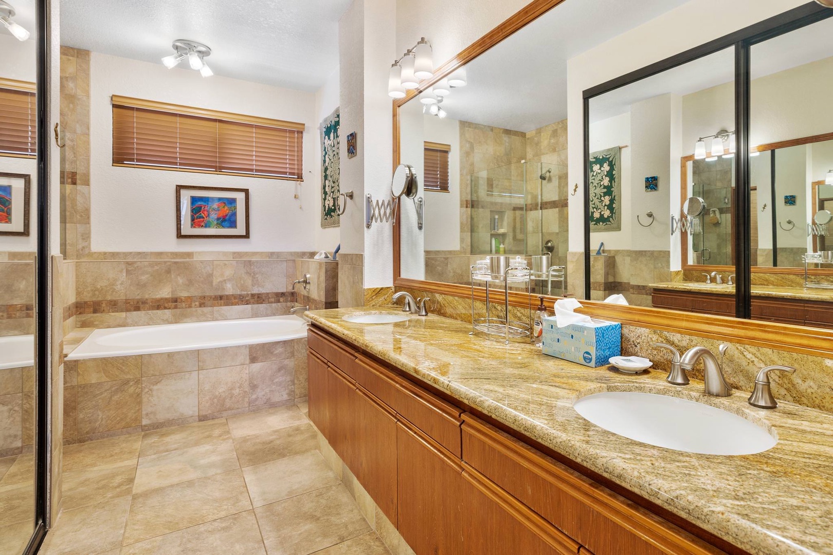 En suite bathroom with dual sinks, soaking tub, and standing shower