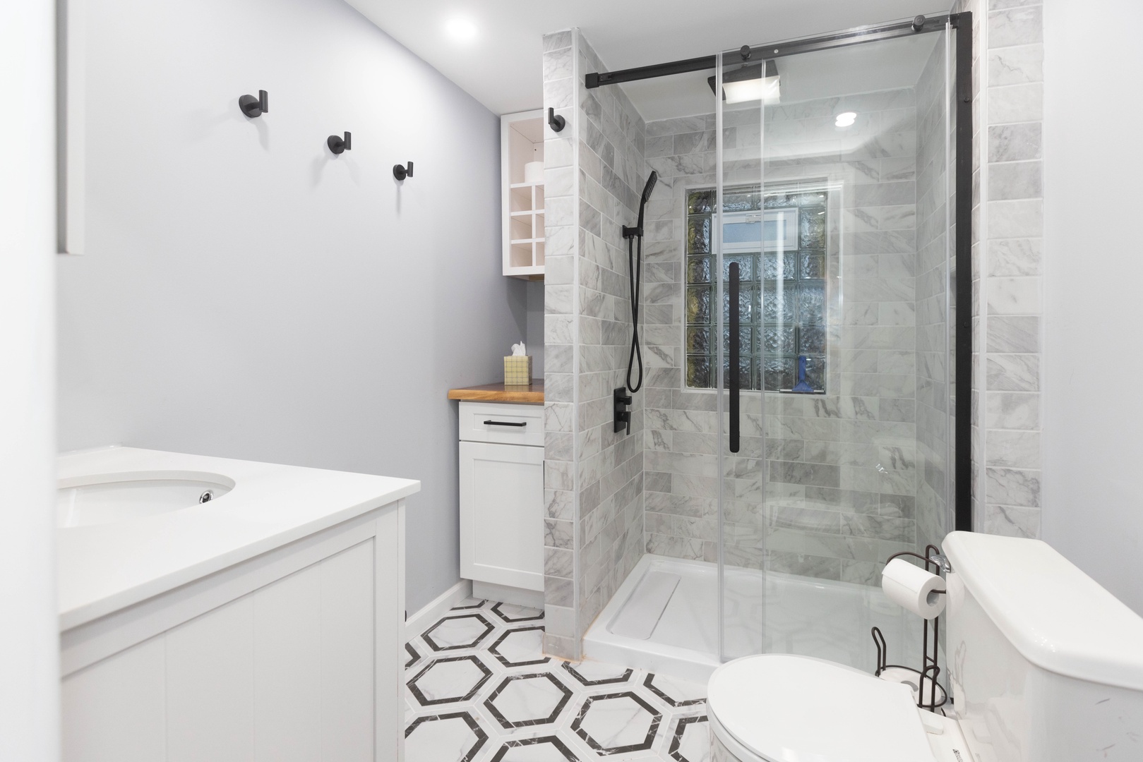 The apartment’s full bathroom offers a single vanity & glass shower