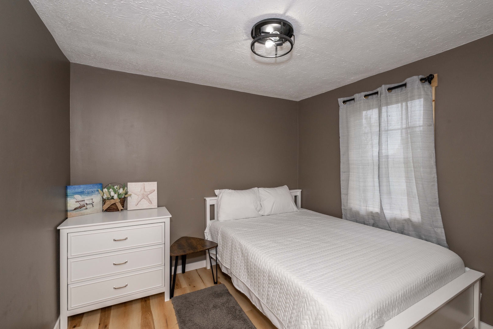 The final bedroom showcases a cozy queen bed