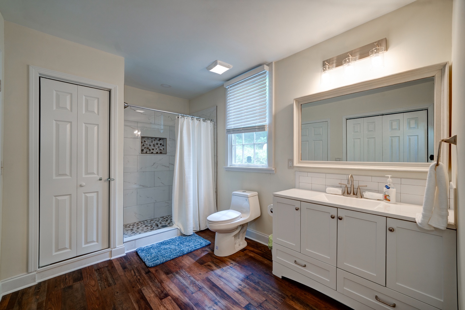 The ensuite features a large single vanity, laundry, & walk-in shower