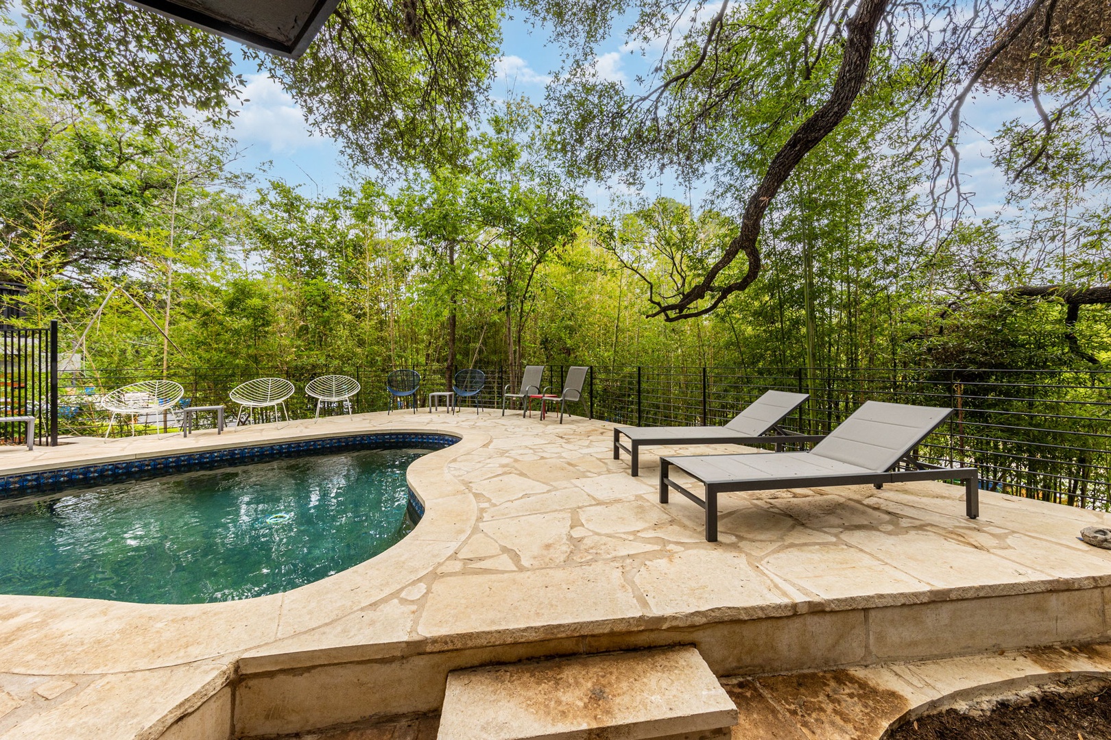 Pool with ample seating under lush trees