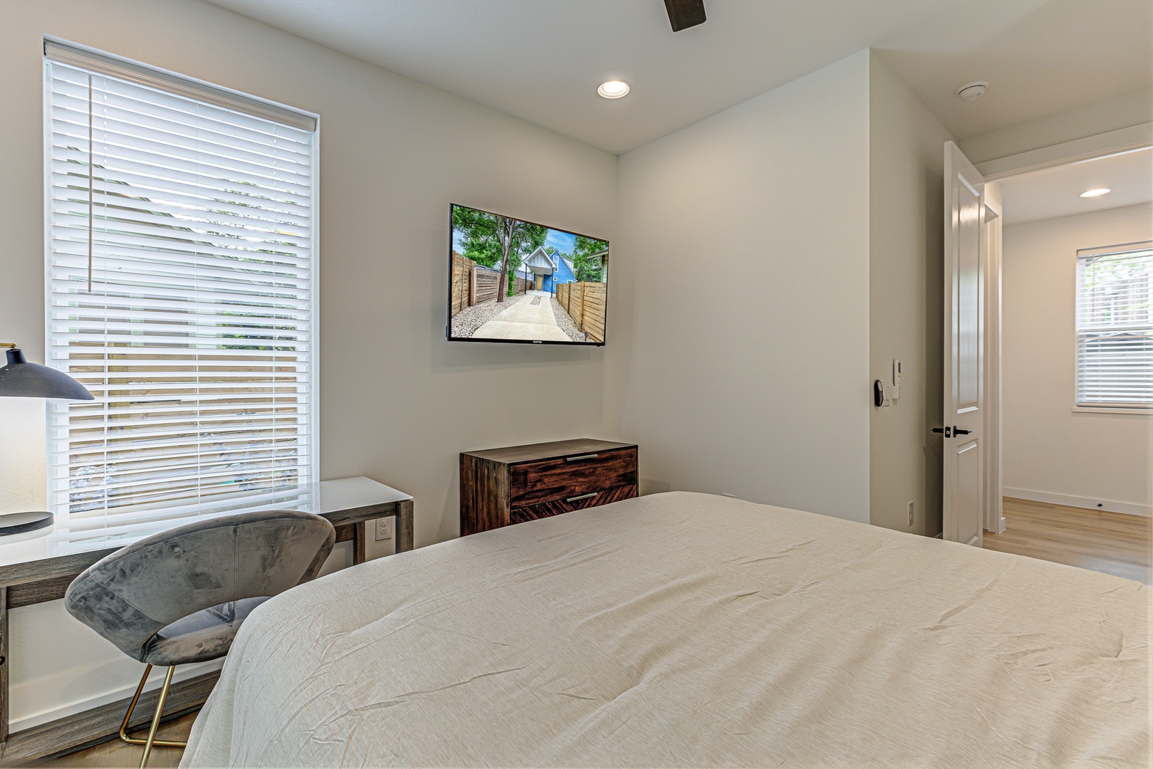 Bedroom 1 with queen bed, patio, workspace, and Smart TV