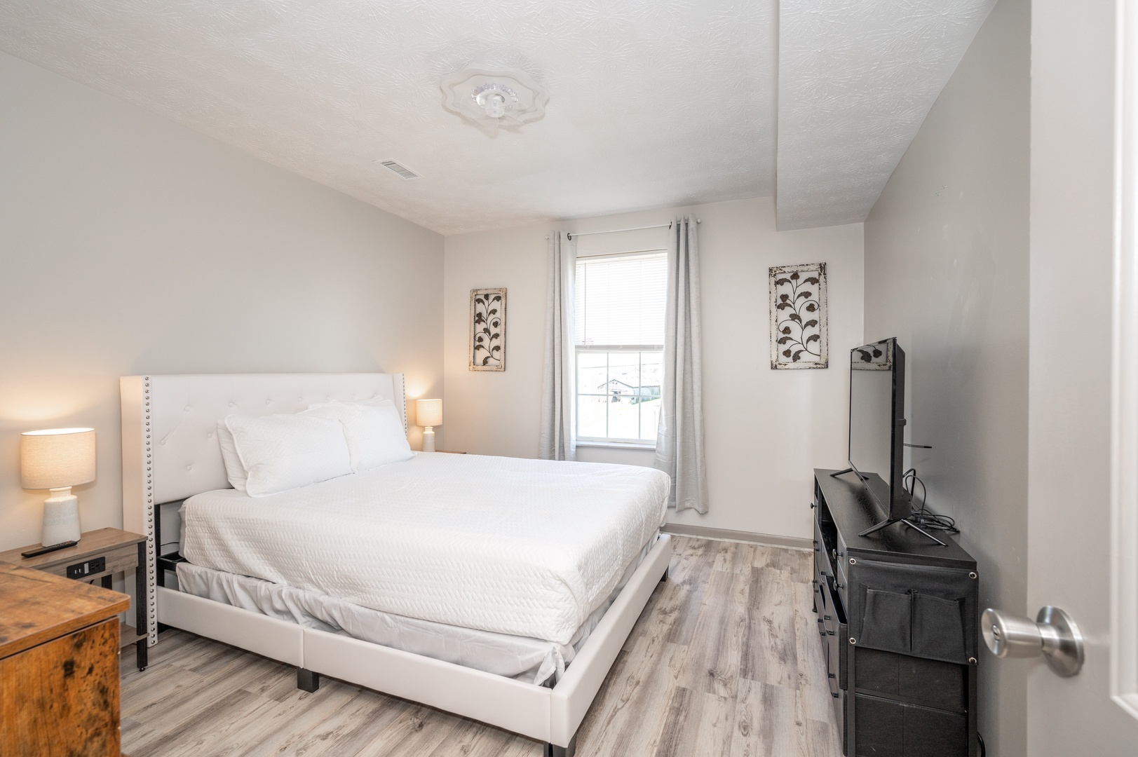 The first of two spacious bedrooms boasts a plush queen bed & Smart TV