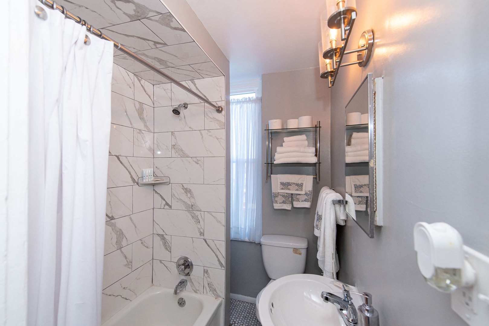Suite 1 – The full bathroom includes a pedestal sink & shower/tub combo