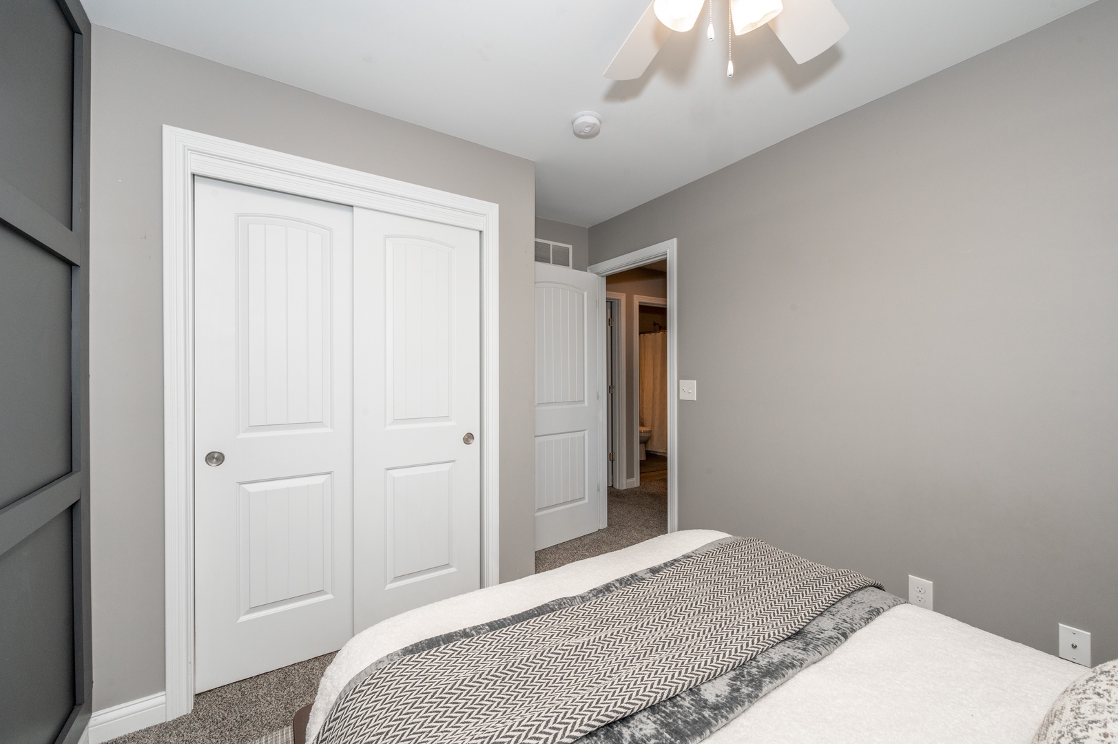 This main-level bedroom includes a queen bed & ceiling fan