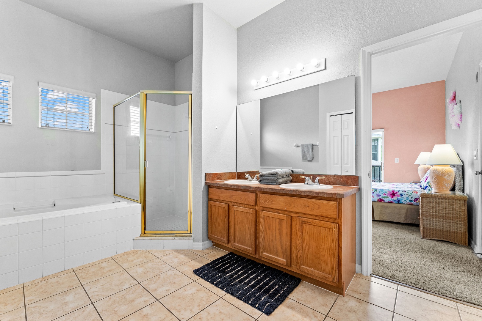 Private ensuite with dual vanity, soaking tub, shower, & shared access