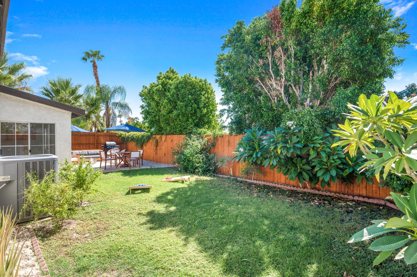 The fenced back yard offers space to lounge, grill, dine & play