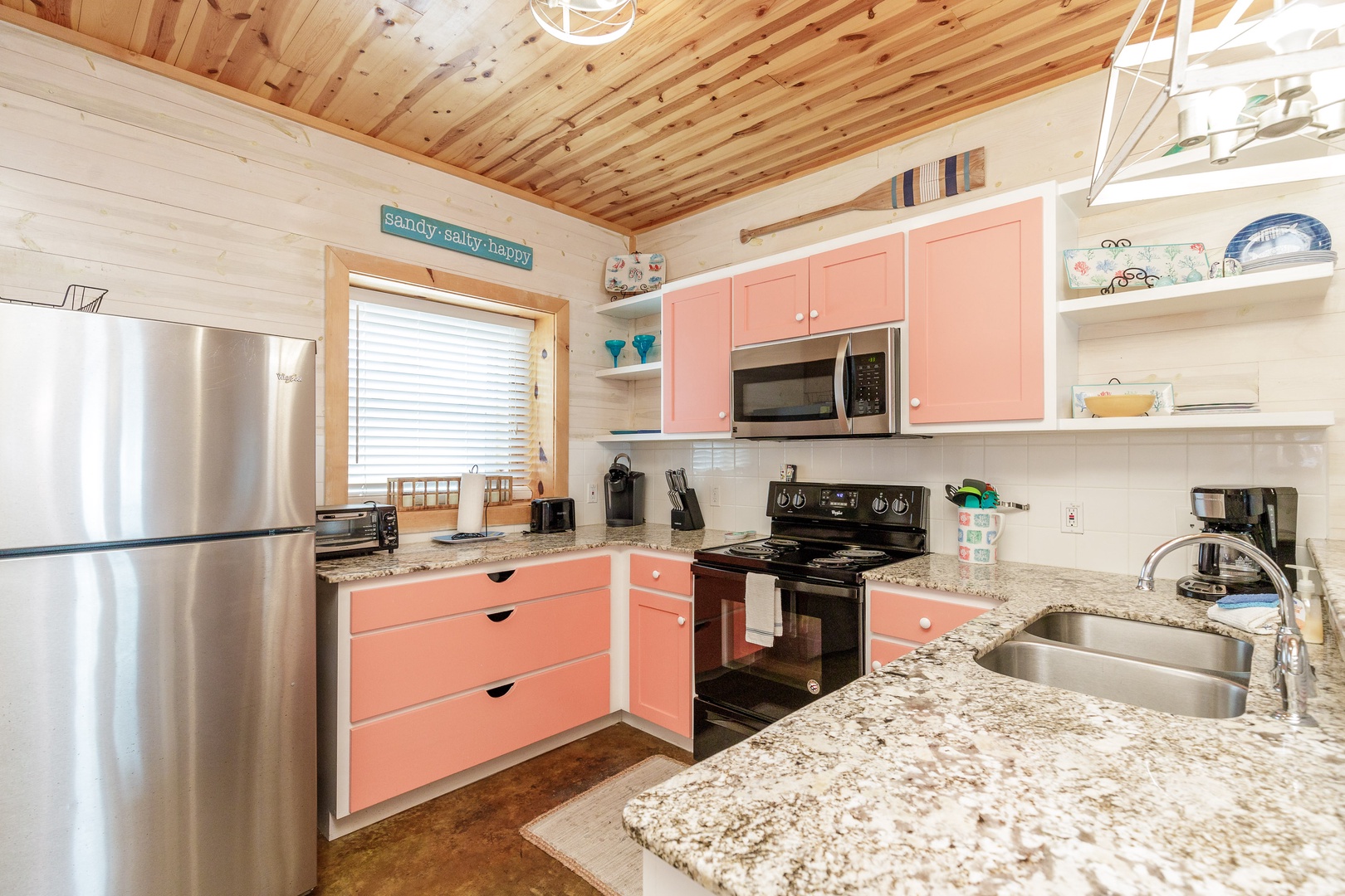 The colorful coastal kitchen offers ample space & all the comforts of home