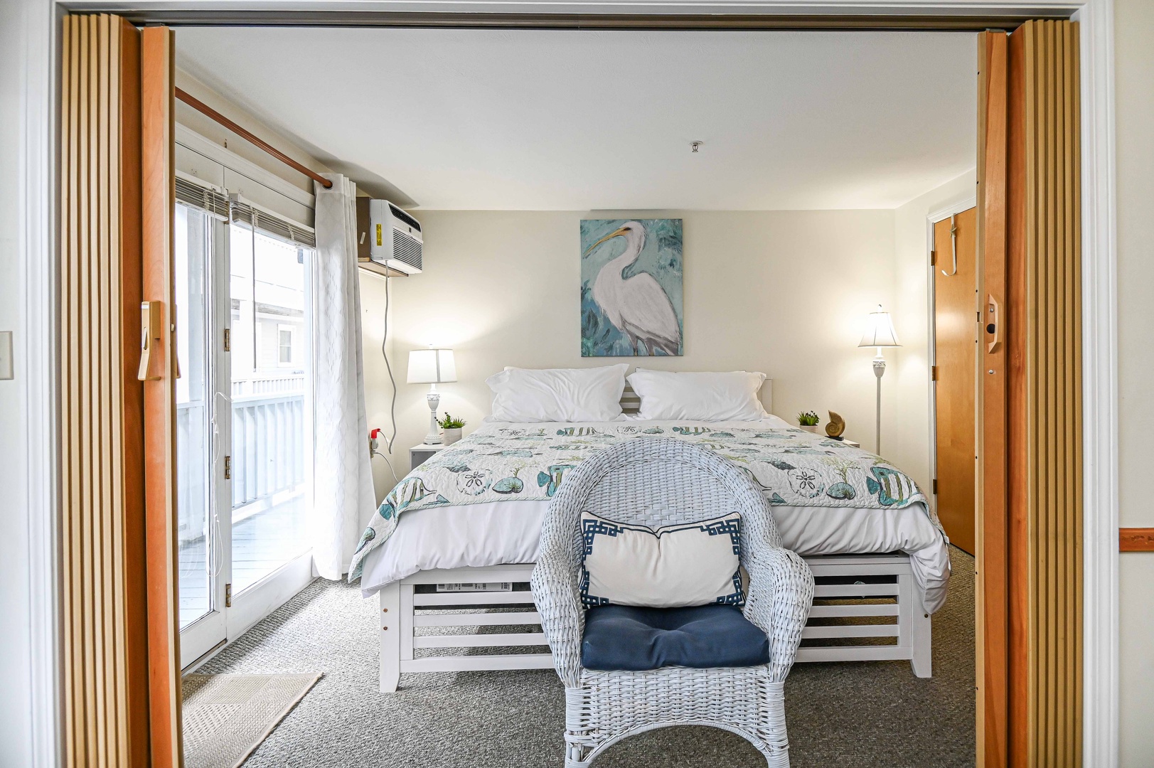 The spacious, coastal bedroom features a plush king-sized bed