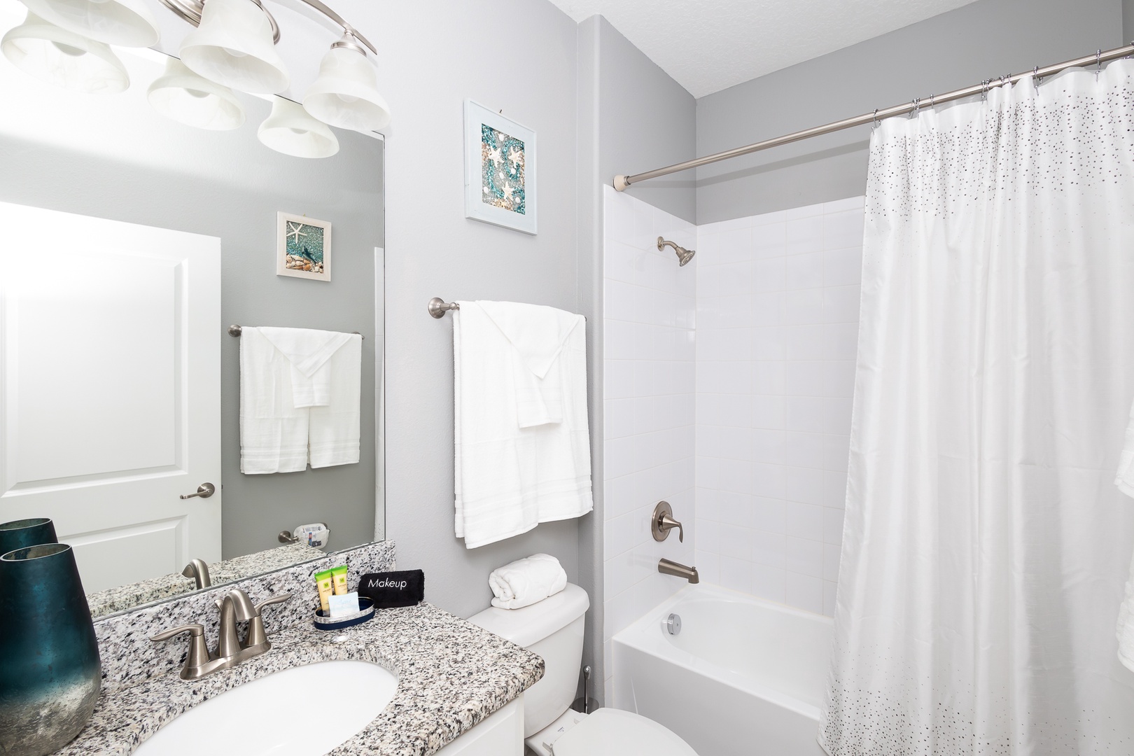 Shared bathroom with single vanity and  shower/tub combo