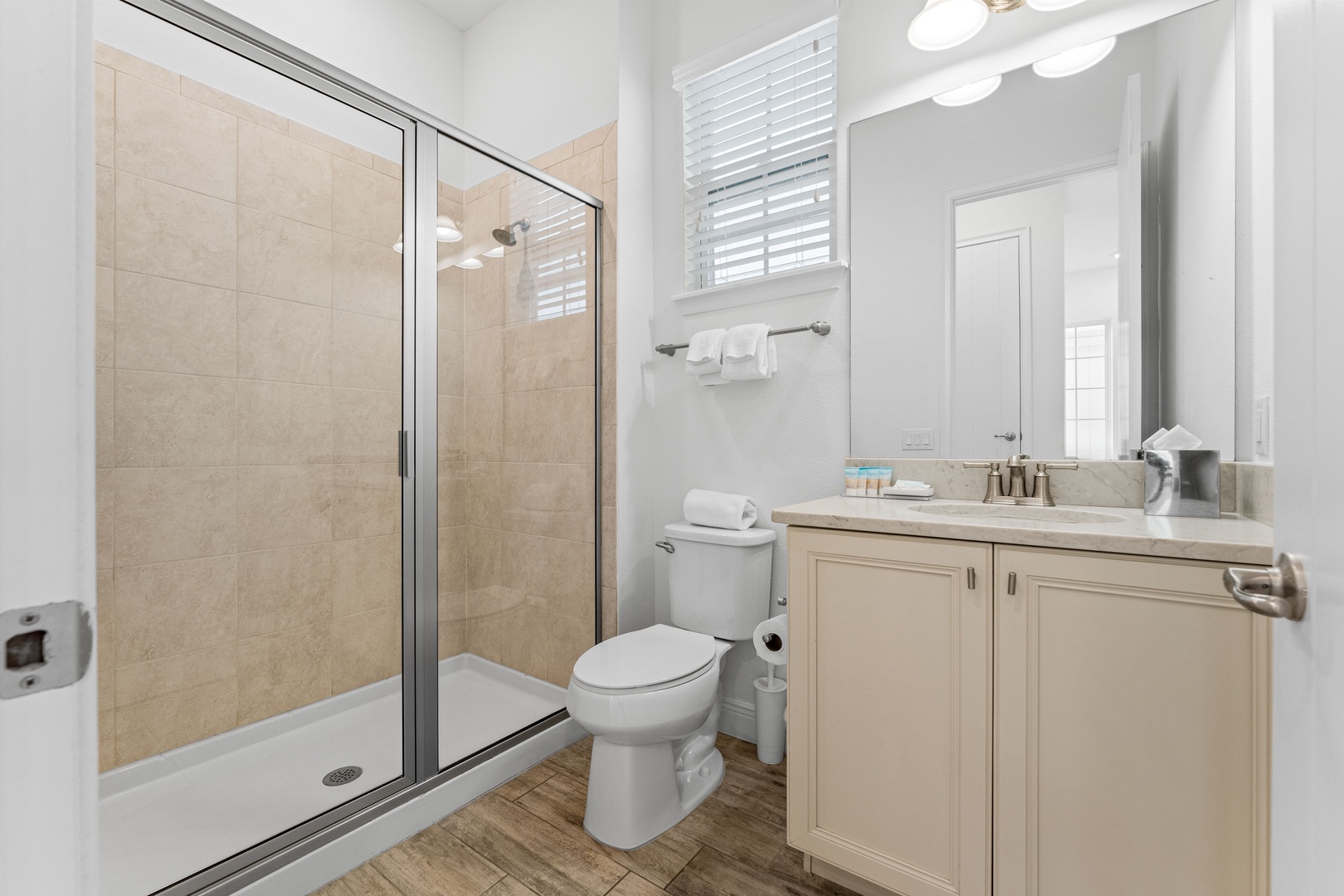 Shared bathroom with single vanity and walk-in shower