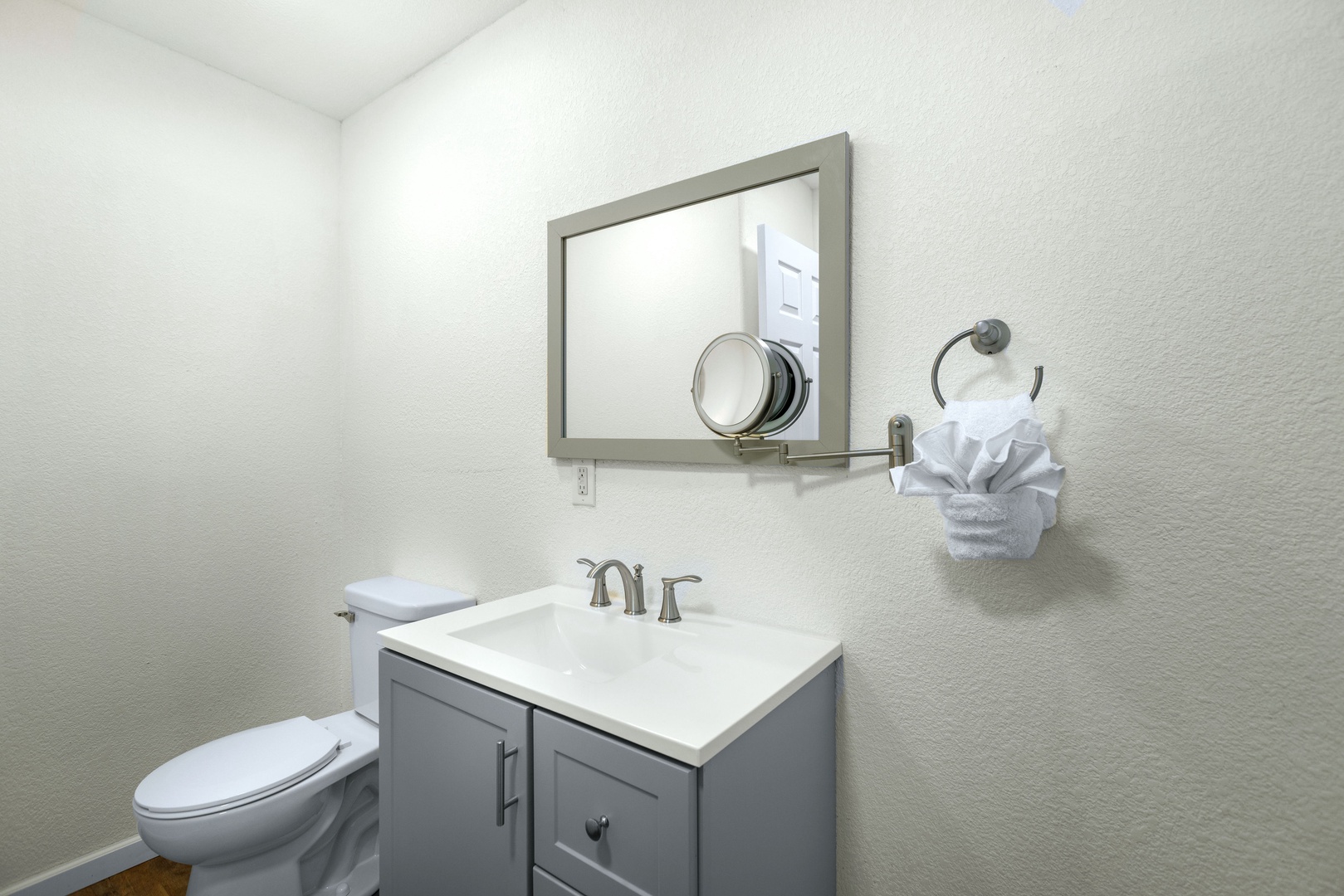 This home offers a stylish, convenient half bath with magnifying mirror