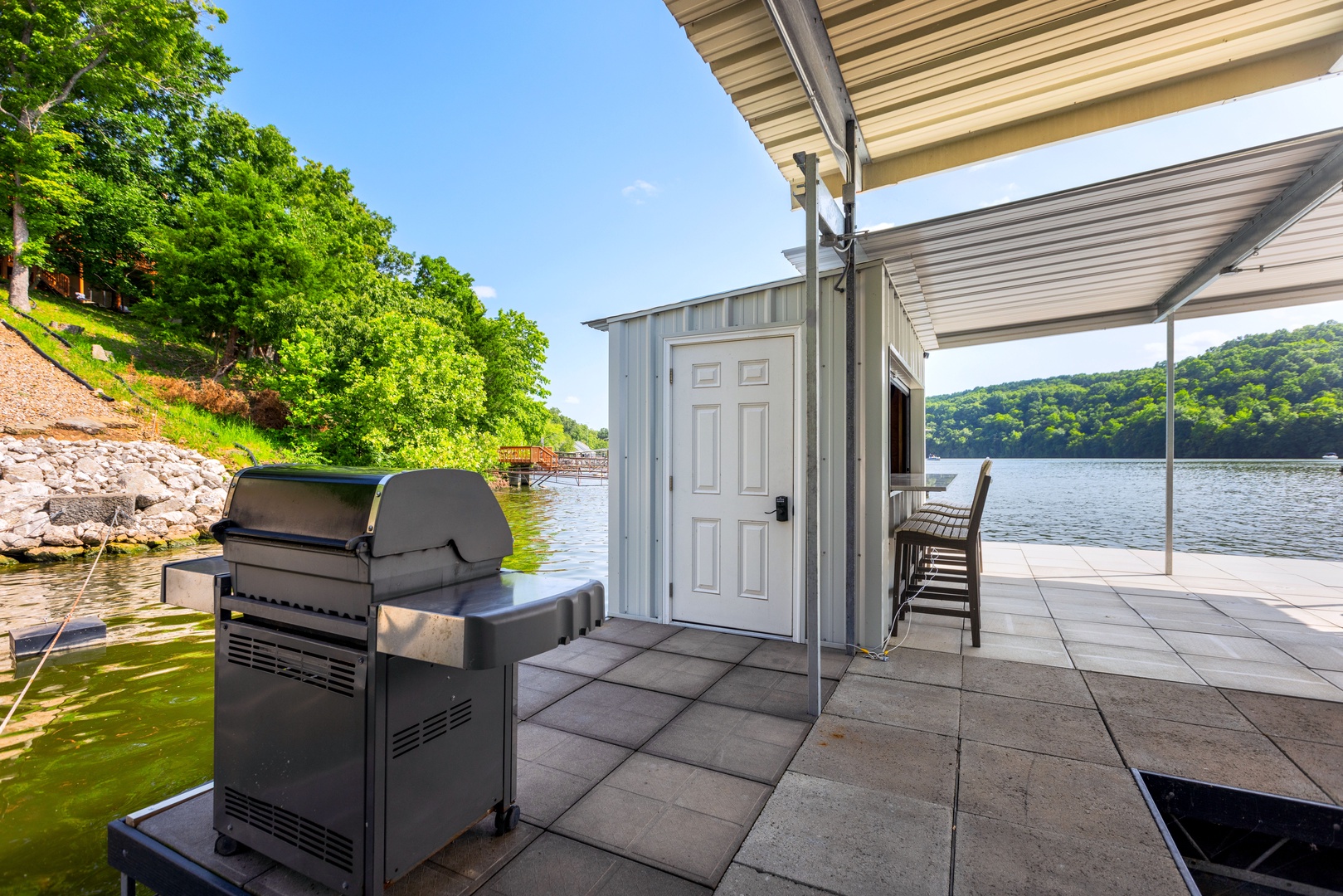 Experience the ultimate dock with BBQ, bar, ample seating, 2 kayaks, a water mat, and a convenient boat slip